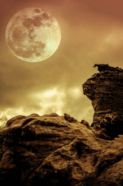Rochers contre ciel avec nuages et belle pleine lune la nuit
. - Photo, image