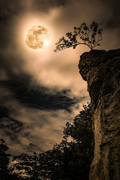 Валуни проти неба з похмурим і красивим повним місяцем. Вінтажний тон
. - Фото, зображення