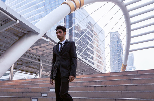 Confident businessman going down and walking on stairs - Foto, Imagem