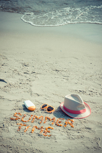 Vintage photo, Inscription summer time, sunglasses, sun lotion and straw hat on sand at beach, summer time - Foto, Imagen