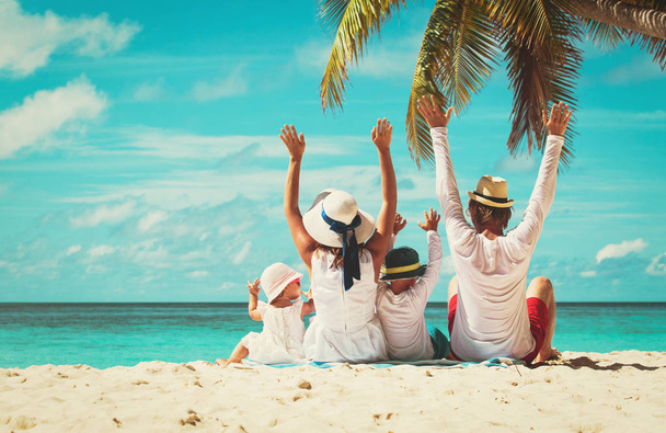 счастливая семья с двумя детьми взялась за руки на пляже
 - Фото, изображение