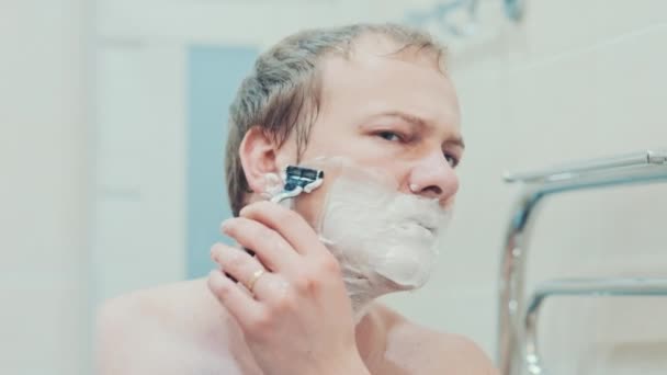 a man shaves in the bathroom. Slow motion - Filmati, video