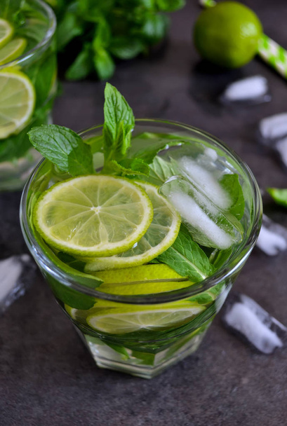 Mojito cocktail on black background with mint and lime - Фото, изображение
