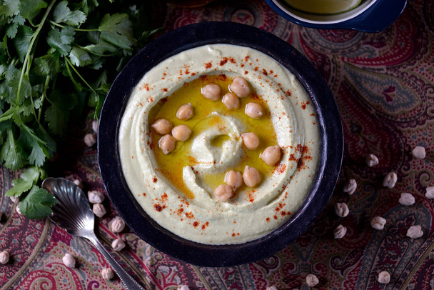 Hummus dip with olive oil and red paprika. - Foto, afbeelding