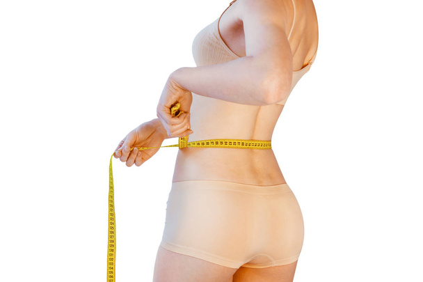 schlanke Frau, die ihre Taille über weißem Hintergrund misst - Foto, Bild