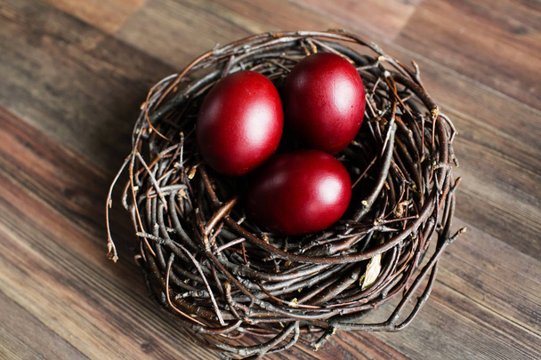 Easter eggs in the nest on wooden background - Foto, imagen