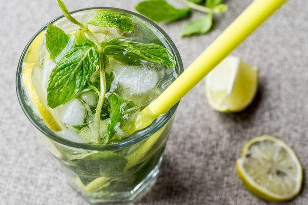 Mojito cocktail with lime, mint leaves and ice. - Фото, изображение