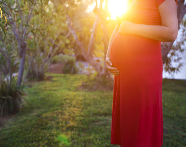 terhes nő pihentető kívül, a parkban - Fotó, kép