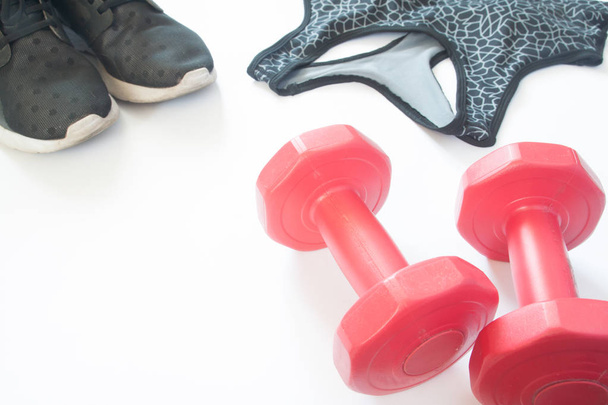 Closeup of red dumbbells with sneaker shoes and sport bra, Sport - Photo, Image