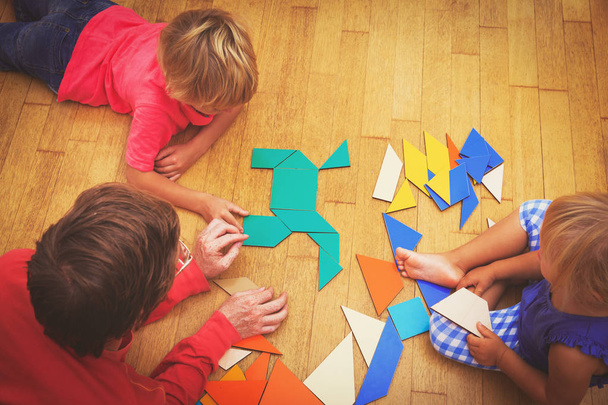 учитель и дети играют с геометрическими фигурами
 - Фото, изображение
