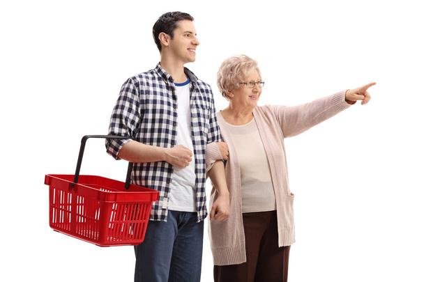 man holding a shopping basket with elderly woman pointing - 写真・画像
