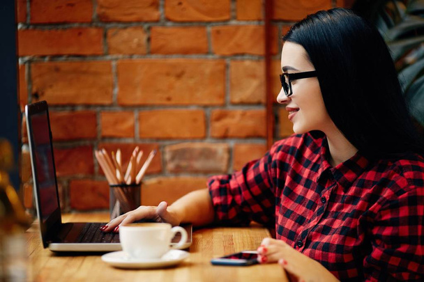 Девушка сидит в кафе с ноутбуком
  - Фото, изображение