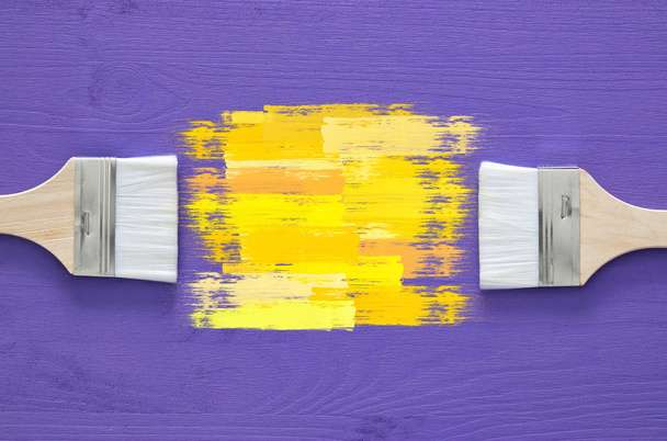 paint brushes and yellow stroke on purple background - Foto, Imagem