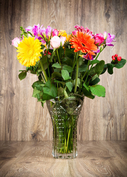 Mixed beautiful flowers in the vase on wooden background - Photo, Image