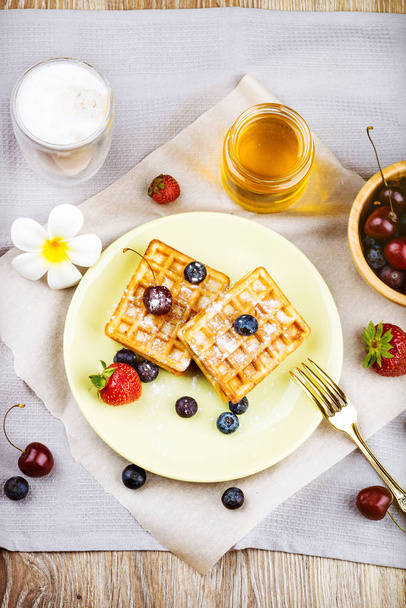 Waffles with berries on wooden background - Photo, image