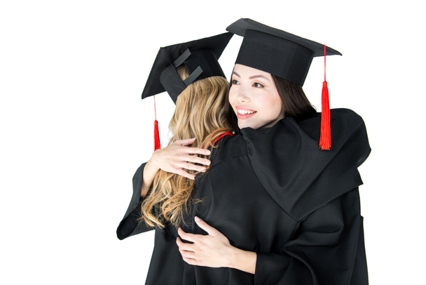 students in graduation caps hugging - Фото, изображение