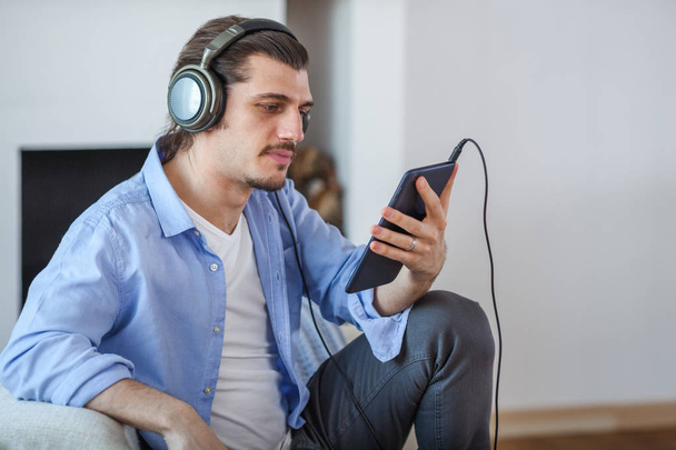 Handsome guy listening to music on internet with tablet - Photo, Image