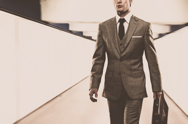 Uomo in abito classico con valigetta passeggiando per il corridoio
 - Foto, immagini