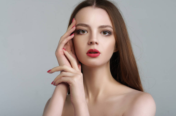 Beauty portrait of an attractive girl who folded her hands near  - Zdjęcie, obraz