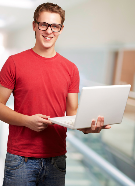 Portret van een jonge man met een laptop - Foto, afbeelding