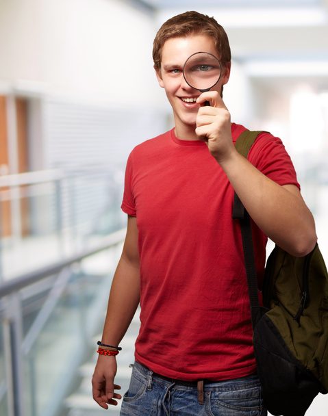 Portrait d'un étudiant regardant à travers le verre grossissant
 - Photo, image