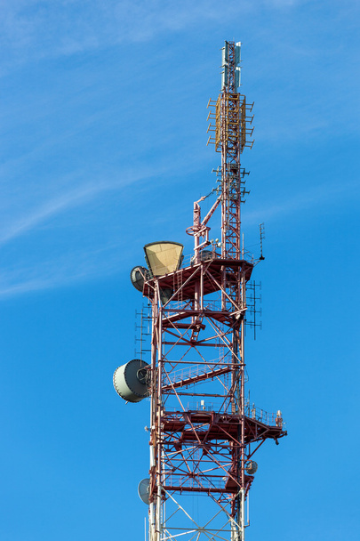 Πύργος τηλεπικοινωνιών με κεραίες πάνω από ένα μπλε ουρανό. - Φωτογραφία, εικόνα
