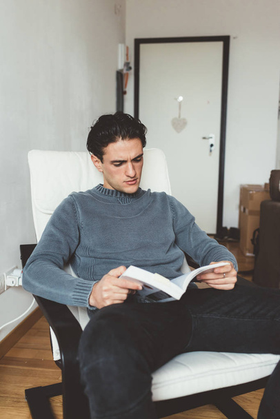 mies istuu sisätiloissa lukeminen kirja
 - Valokuva, kuva