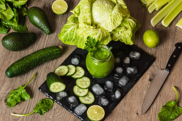 Детоксикаційна дієта. Зелений смузі з різними овочами на дерев'яному фоні
 - Фото, зображення