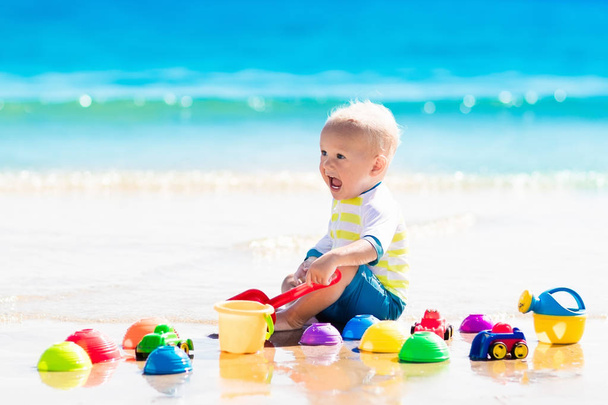 砂を掘る熱帯のビーチで遊んで赤ちゃん - 写真・画像