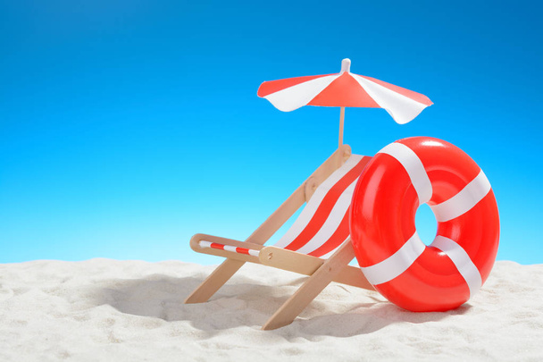 Deckchair y anillo de natación en la playa
 - Foto, imagen