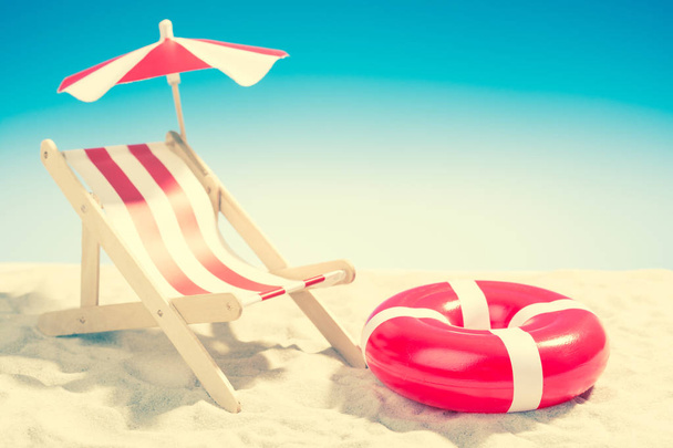 Deckchair y anillo de natación en la playa
 - Foto, imagen