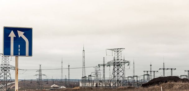 elektriciteit distributie station in de buurt van de snelweg, teken van vernauwing van de weg - Foto, afbeelding