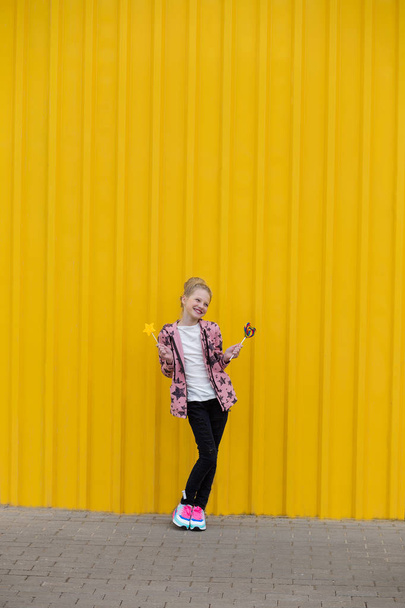 Portrait of a beautiful girl with red lips on a yellow backgroun - Foto, imagen