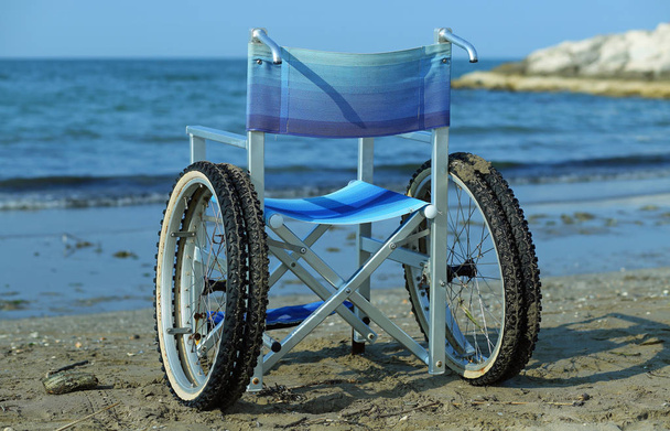 silla de ruedas moderna junto al mar en verano con ruedas grandes
 - Foto, imagen
