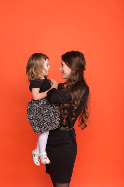 Beautiful young girl in a business suit and little girl in a bla - Photo, Image
