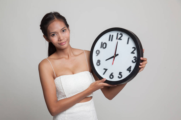 Young Asian woman with a clock. - Fotó, kép