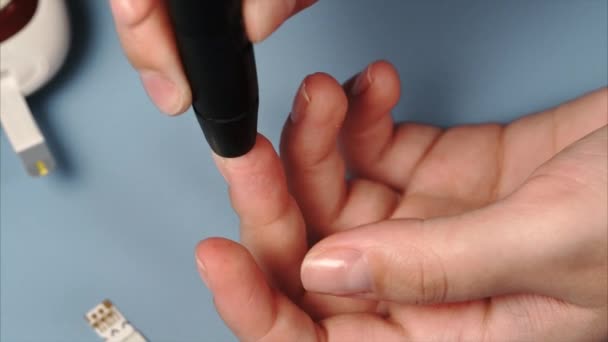Žena používající lancet a glucomete pro měření cukru v krvi - Záběry, video