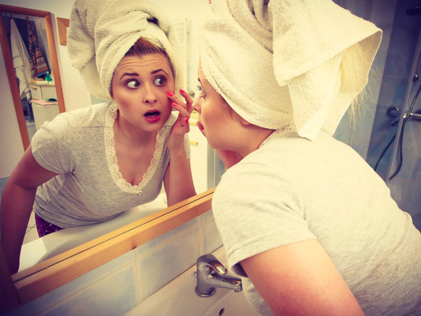 Woman looking at her reflection in mirror - Valokuva, kuva