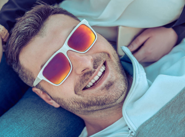 Mosolygó szakállas ember színes napszemüveget visel - Fotó, kép