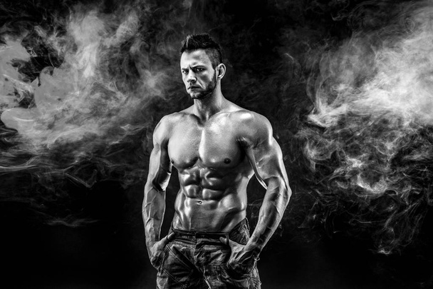 Strong bodybuilder man in military pants with perfect abs, shoulders, biceps, triceps, chest - 写真・画像