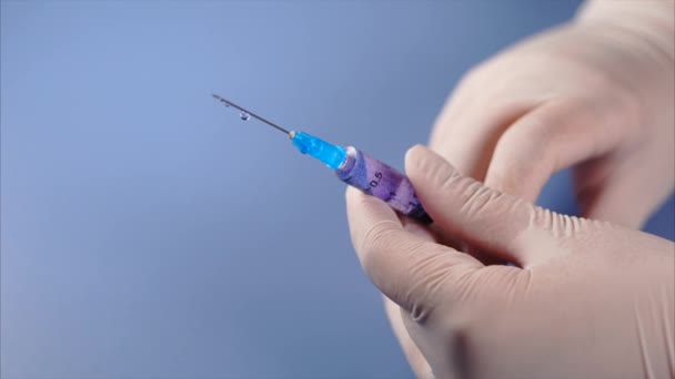 Syringe in doctors hands. Medicine leaking from a syringe. - Footage, Video