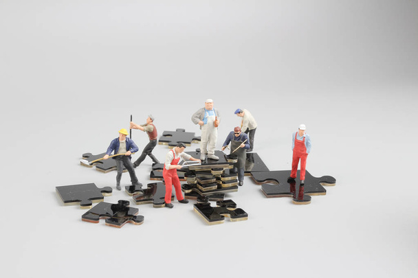 mini minuscules constructeurs sur le chantier de construction de puzzle
 - Photo, image