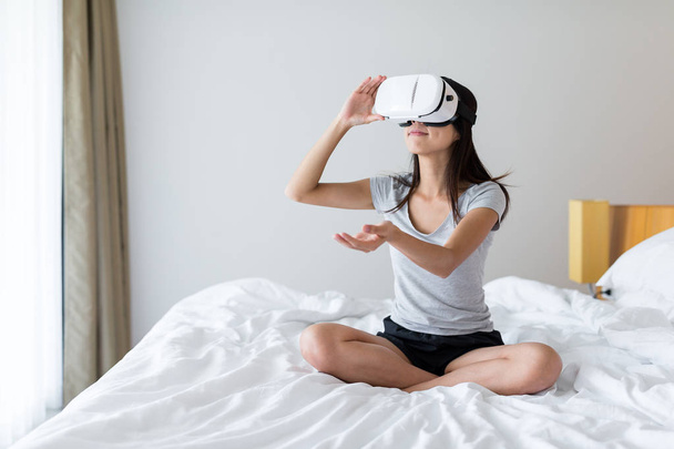 Woman wearing VR device at home - Foto, afbeelding