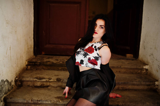 Young goth girl on black leather skirt and jacket posed on stair - Foto, Bild
