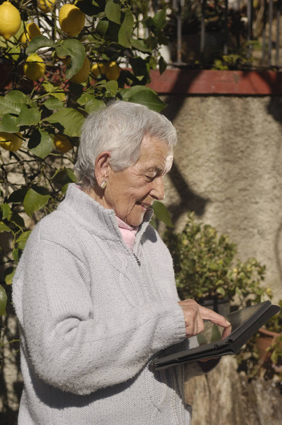 Oude vrouw met een tabel buiten - Foto, afbeelding