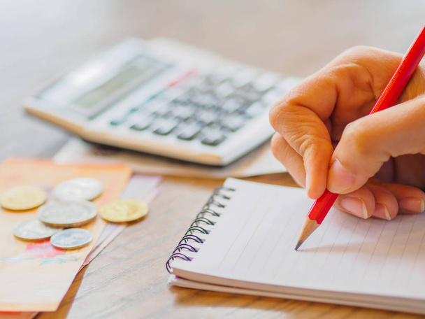Mulher usando calculadora e pensando sobre o custo na mesa no escritório em casa
. - Foto, Imagem