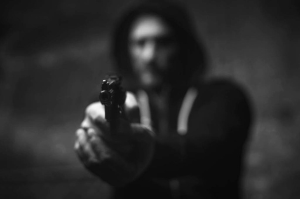 Dreaded brutal bandit holding his victim on gunpoint - Foto, afbeelding
