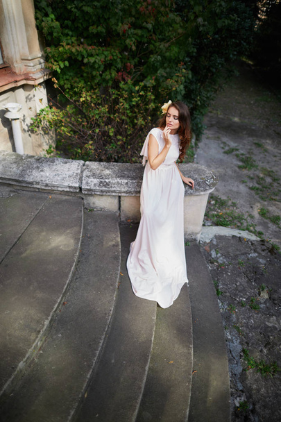bruid met krullend haar in trouwjurk  - Foto, afbeelding