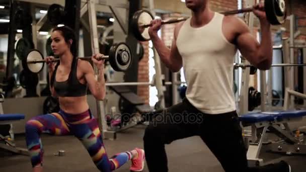 Paar Sportler machen Kniebeugen mit Hanteln - Filmmaterial, Video