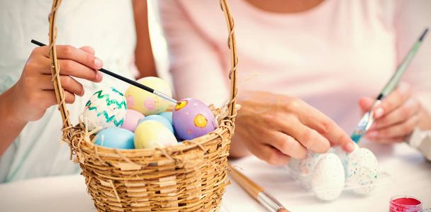 mother and daughter painting easter eggs - 写真・画像